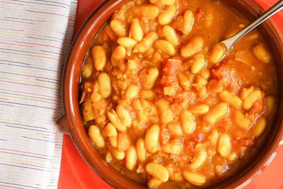 Hearty Moroccan Loubia white bean stew garnished with fresh parsley and olive oil