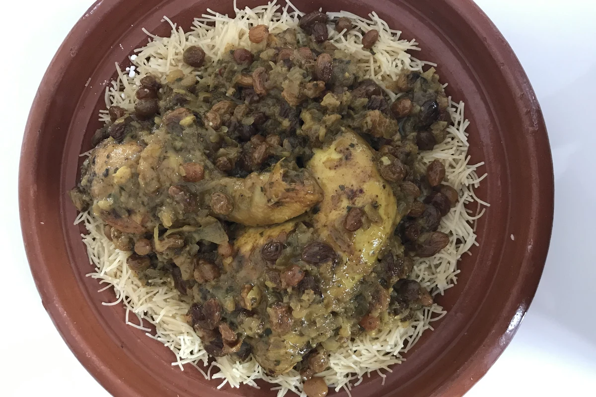 Moroccan Seffa Medfouna decorated with cinnamon stripes, powdered sugar, and fried almonds
